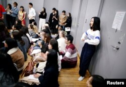 Yuri Harada, 19, a student at Waseda University, stands against the back wall while attending club activities at her university in Tokyo, Japan, April 9, 2019.