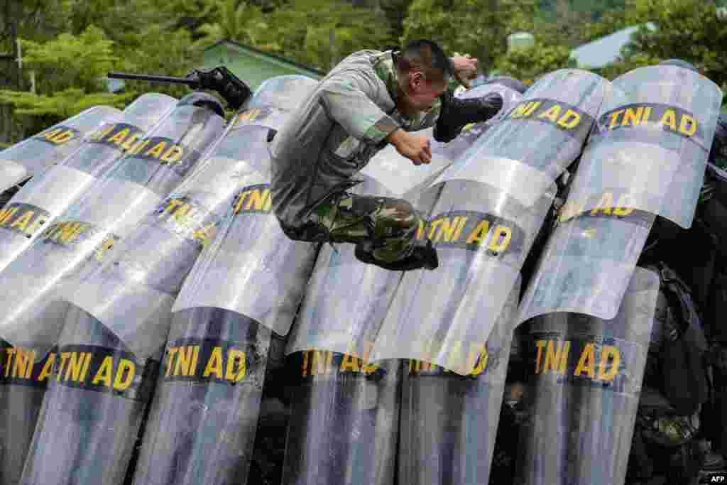 Indonesian soldiers take part in a handling riots practice ahead of the elections at their military home base in Banda Aceh, Aceh province.