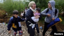 FILE - Migrants cry and walk towards Gevgelija in Macedonia after crossing Greece's border, Macedonia. 