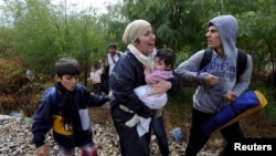 FILE - Migrants cry and walk towards Gevgelija in Macedonia after crossing Greece's border, Macedonia, Aug. 22, 2015. 
