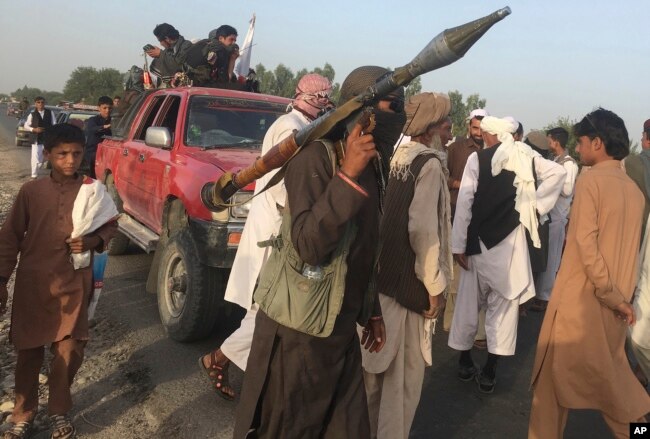 FILE - Taliban fighters are seen gathered in Surkhroad district of Nangarhar province, east of Kabul, Afghanistan, June 16, 2018.