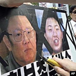 韩国活动人士划开金正日像 示威者说右侧为金正银