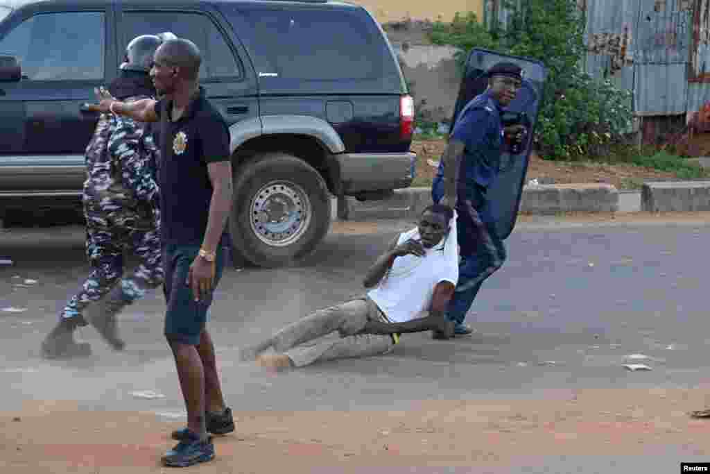 An anti-riot policeman drags away a supporter of Sierra Leone People&#39;s Party (SLPP) during a protest against the police attempting to search the offices of Julius Maada Bio, the presidential candidate for (SLPP) in Freetown, Sierra Leone, March 7, 2018.