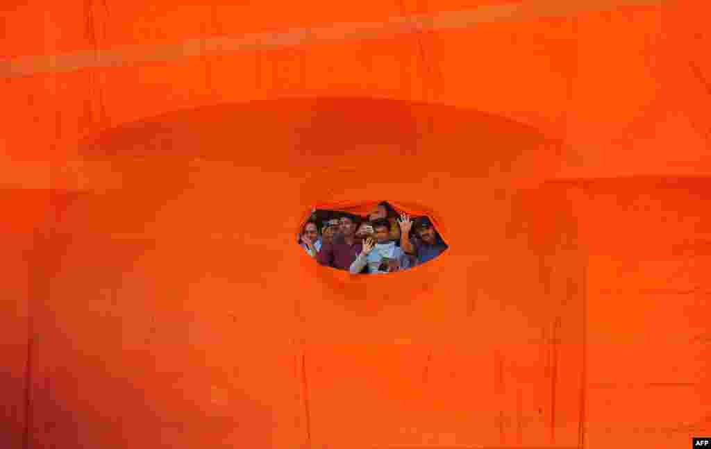 Supporters of India's main opposition wave at their candidate, Narendra Modi, as he arrives to file his election nomination papers in Varanasi.