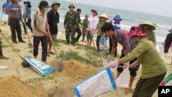 FILE- In this April 28, 2016, file photo, villagers bury dead fish on a beach in Quang Binh, Vietnam. Toxic waste discharged from a Taiwanese-owned Formosa Plastics Group steel complex unit in central Vietnam harmed the livelihoods of more than 200,000 people, including 41,000 fishermen, the Vietnamese government said on Friday in tallying the damage from what it has called the country’s worst environmental disaster according to local media. The company has pledged to pay $500 million in compensation.