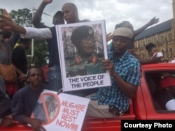 FILE: Zimbabwean protesters carrying Army Commander Constantino Chiwenga