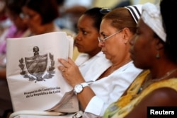 A Cuban nurse holds the draft proposal of changes to the constitution during the beginning of a public political discussion to revamp a Cold War-era constitution at the Nguyen Van Troi Polyclinic in Havana, Aug. 13, 2018.