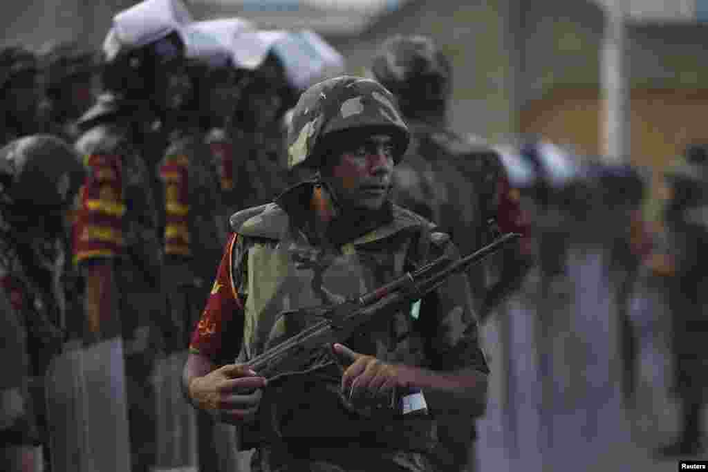 Army soldiers take their positions in front of protesters who are against President Mohamed Morsi, near the Republican Guard headquarters in Cairo, July 3, 2013. 