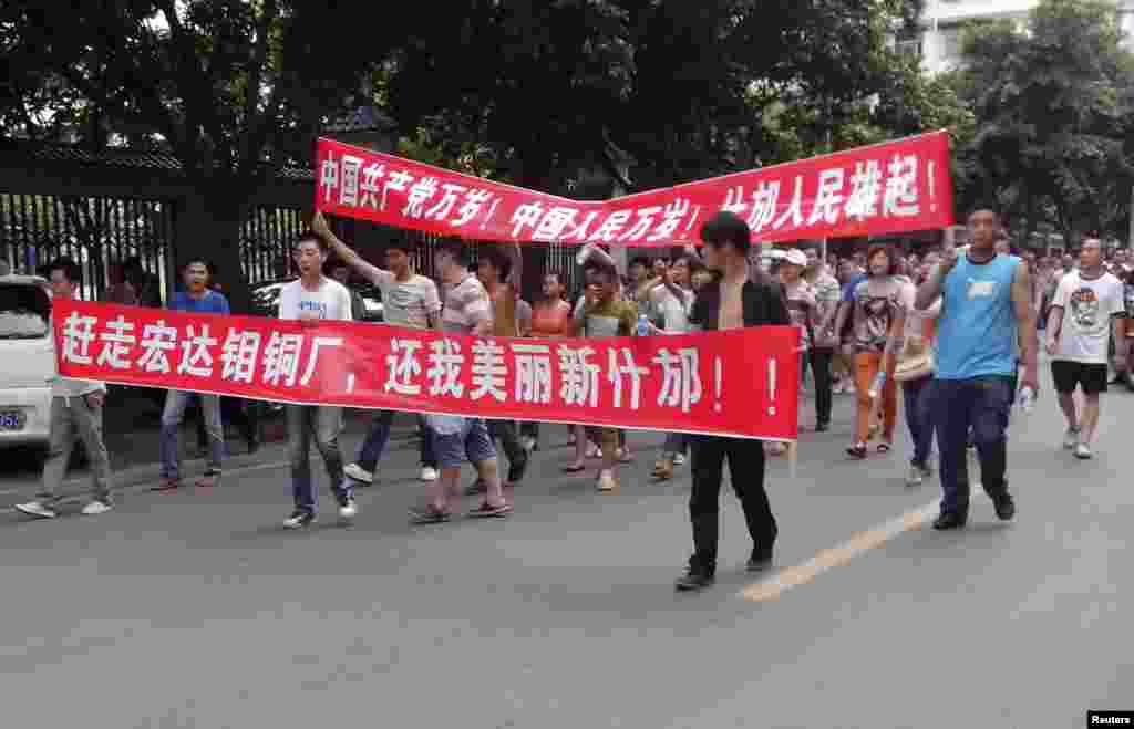 Local residents march with banners during a protest along a street in Shifang, Sichuan province, China, July 3, 2012.