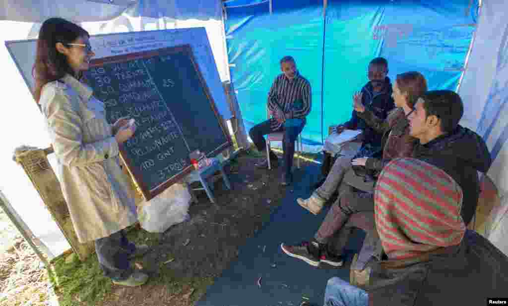 Europe&#39;s migration crisis has spilled over into a muddy park in Brussels where hundreds of migrants are camping in tents not far from the European Union&#39;s headquarters in one of the most visible signs of the urgency facing the bloc&#39;s officials. In this image, migrants attend French lessons at a makeshift camp outside the foreign office in Brussels.