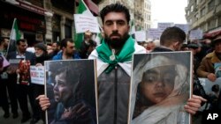 People holding pictures of victims of the airstrikes and shelling in Ghouta, a suburb of Damascus, gather during a rally outside the Russian Consulate in Istanbul, Feb. 22, 2018. 