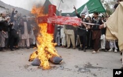 Des Afghans brûlent une photo du président Barack Obama lors d'une manifestation à Jalalabad (13 mar 2012)