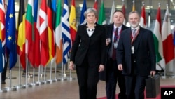 FILE - British Prime Minister Theresa May, left, arrives for an EU summit at the Europa building in Brussels, March 23, 2018.