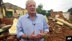 FILE - U.N. humanitarian chief Stephen O'Brien answers reporters' questions during an organized trip to Bangassou, Central African Republic, July 18, 2017. Recent attacks have prompted 14 humanitarian workers from six organizations to suspend activities in Bangassou.