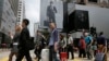 FILE - Mainland Chinese tourists carry suitcases as they walk at a shopping district in Hong Kong, April 12, 2015.