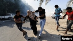 Anti-government protesters run from tear gas fired by riot police, as they attempt to get to the village of Diraz, west of Manama, November 9, 2012.