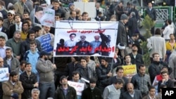 Iranian regime loyalists hold a poster with doctored pictures of former president Mohammad Khatami (L) and opposition leaders Mir Hossein Mousavi (C) and Mehdi Karroubi on the gallows during a pro-government demonstration in Tehran, February 18, 2011