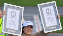 La piloto belga-británica Zara Rutherford, de 19 años, sostiene sus certificados de récord mundial Guinness luego de su aterrizaje en el aeropuerto de Kortrijk-Wevelgem, después de un viaje alrededor del mundo en un avión ligero, en Wevelgem, Bélgica, 20 de enero de 2022. REUTERS/Pascal Rossignol