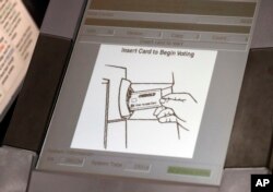 This photo shows a touchscreen of a voting machine during early voting in Sandy Springs, Ga., May 9, 2018. The fact that many voting machines used by Americans do not produce paper records worries cybersecurity experts.