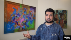 이라크 출신 난민 아흐매드 알카키 씨가 자신의 작품 앞에서 VOA와 인터뷰하고 있다.