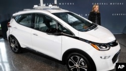 FILE - General Motors Chairman and Chief Executive Officer Mary Barra stands next to an autonomous Chevrolet Bolt electric car in Detroit, Dec. 15, 2016.