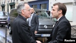 French President Emmanuel Macron (R) is welcomed by the archbishop of Marseille and president of the Bishops' Conference of France (CEF) Georges Pontier, upon his arrival at a meeting of the Bishops' Conference of France (CEF) at College des Bernardins in Paris, April 9, 2018. 