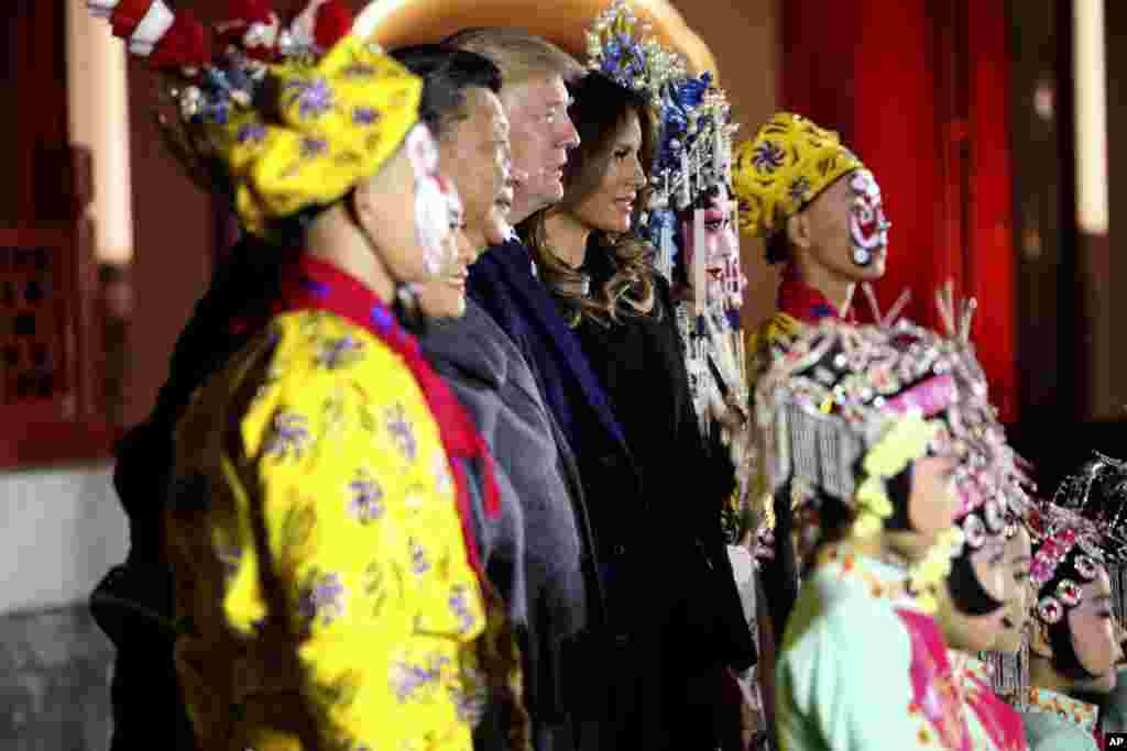 លោក​ប្រធានាធិបតី ដូណាល់ ត្រាំ (កណ្តាល) និង​លោកស្រី Melania Trump (កណ្តាល​ខាង​ស្តាំ) ឈរ​អម​លោក​ប្រធានាធិបតី​ចិន Xi Jinping និង​ភរិយា​របស់​លោក គឺ​លោកស្រី Peng Liyuan នៅ​ពេល​ថត​រូប​ជាមួយ​នឹង​អ្នក​សម្តែង​សិល្បៈ​នៅ​អតីត​រាជវាំង​កំបាំង Forbidden City នៅ​ថ្ងៃពុធ ទី៨ ខែ​វិច្ឆិកា ឆ្នាំ២០១៧ នៅ​ទីក្រុង​ប៉េកាំង ប្រទេស​ចិន។