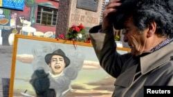 Un ¨fan¨de Carlos Gardel rinde tributo ante el monumento del cantante en Montevideo. Una partida de nacimiento encontrada en Toulouse prueba que Gardel nació en Francia, no en Argentina o en Uruguay como se creía.