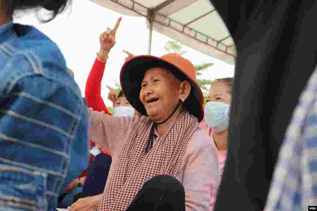 An elderly woman reacts to a show as groups of citizen, workers, and civil society representatives celebrate the 109th International Women Rights Day at Freedom Park, in Phnom Penh, March 8, 2020. (Kann Vicheika/VOA Khmer)