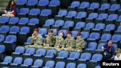 Tentara Inggris duduk di deretan kursi penonton yang kosong saat menyaksikan pertandingan babak penyisihan cabang olah raga senam putri di arena Greenwich utara Olimpiade London 2012 (29/7). 