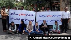 Female victims of a 2012 school fire in the northwestern Iranian city of Shinabad and their supporters stage a protest outside the Tehran office of President Hassan Rouhani, July 18, 2018.