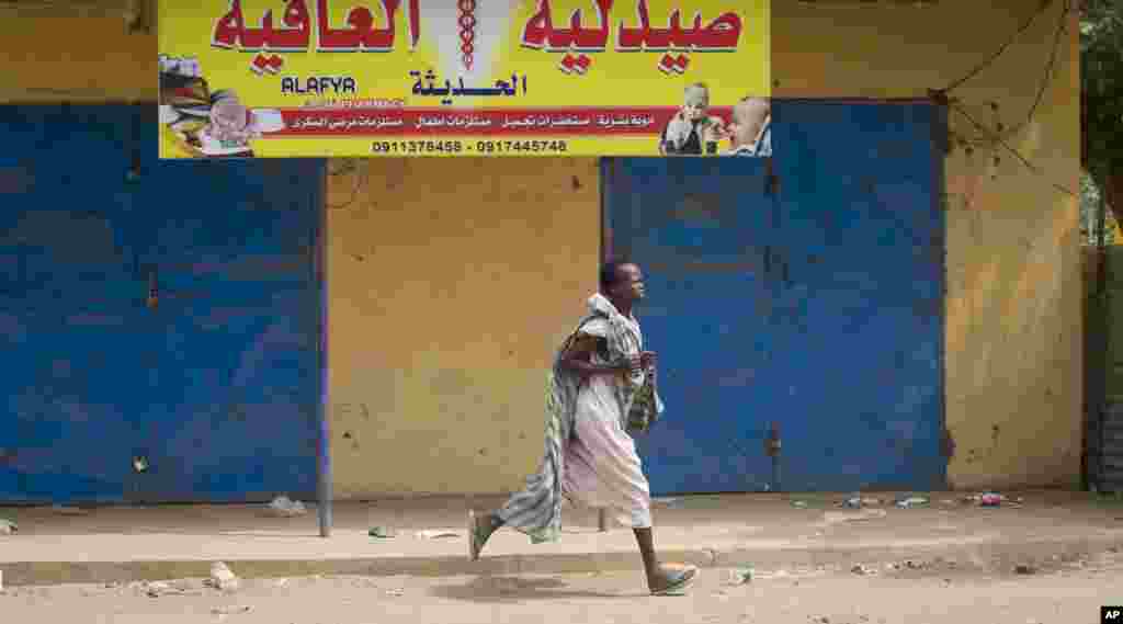 Seorang perempuan berlari sepanjang jalan ketika terdengar tembakan di dekat jalan tersebut di Malakal, negara bagian Upper Nile, di Sudan Selatan.