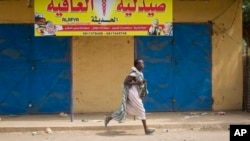 A young woman runs through the street as gunshots ring out a few streets over, in Malakal, Upper Nile State, in South Sudan on Jan. 21, 2014. A ceasefire agreement signed two days later has been repeatedly violated. 