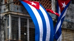 FILE - Cuban flags drape the windows of the home of Yunior Garcia Aguilera, which block his windows and prevent his communicating with the outside, in Havana, Cuba, Nov. 15, 2021. Garcia is one of the organizers of a banned opposition march.
