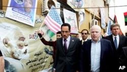 US Rebuplican senator John McCain (R) walks with Abdul Hafiz Ghoqa, spokesman of the Libyan National Transitional Council (NTC), during his tour to the rebel headquarters in their eastern stronghold city of Benghazi (File Photo - April 22, 2011)