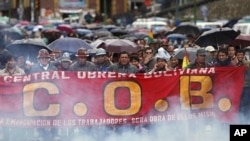 Members of Bolivia's Central Workers union march to protest rising food costs in La Paz; the smoke is from small packages of dynamite set off by the protesters, Feb. 18, 2011