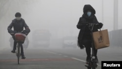 People ride amid the smog in Beijing, China, Feb. 14, 2017. 