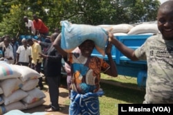 Marita Shati smiles after receiving a bag of maize from Abida Mia's Reach Out and Touch charity in Malawi.