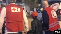 Në këtë fotografi, Alvin Berisha shoqërohet më 6 nëntor për në aeroëportin e Damaskut nga zyrtarë të Kryqit të Kuq dhe Gjysmëhënës së Kuqe. 