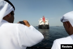 Port officials take a photo of a damaged Andrea Victory ship at the Port of Fujairah, United Arab Emirates, May 13, 2019.