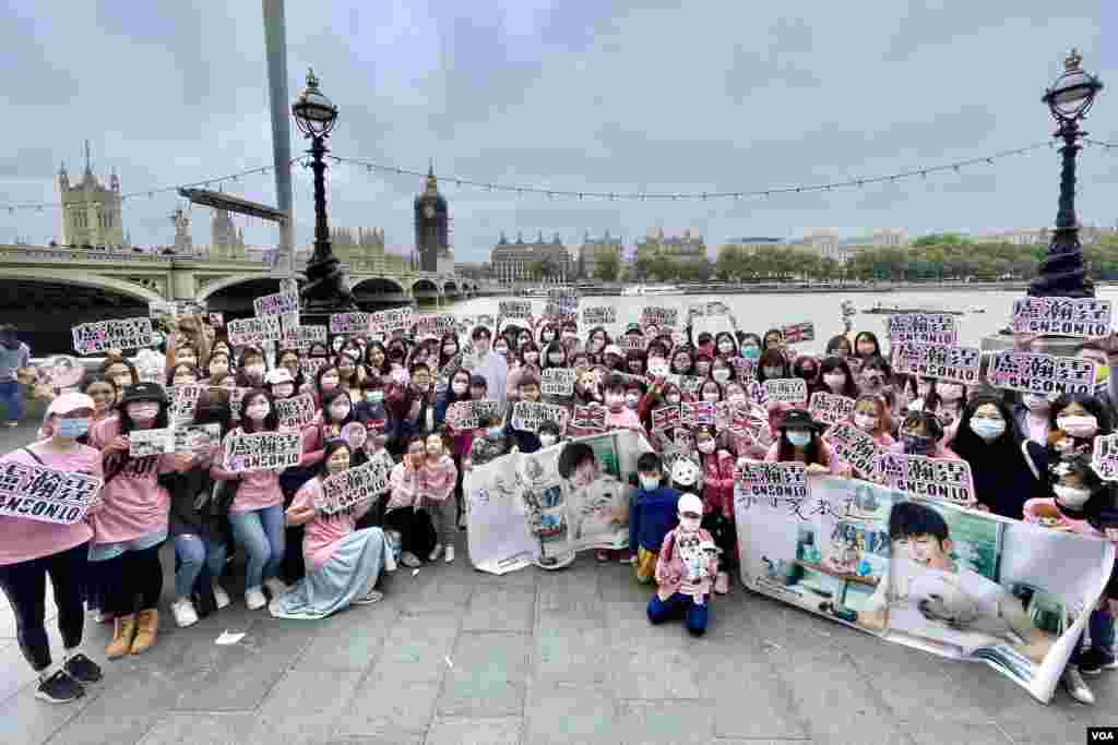 Fans of Mirror singer Anson Lo pose for a group photo in central London, Sept. 25, 2021. The signed banner will be presented to Lo after more fans sign it at many more stops worldwide. (Kris Cheng/VOA Mandarin)