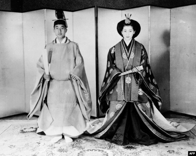 Pangeran Akihito (Kiri) dan istrinya Michiko Shoda mengenakan busana pengantin tradisional pada akhir upacara pernikahan di Istana Kekaisaran di Tokyo, 10 April 1959.(Foto: AFP/Arsip)