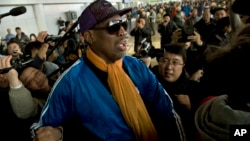 FILE - Former NBA basketball player Dennis Rodman is followed by journalists as he arrives at the Capital International Airport in Beijing from Pyongyang.