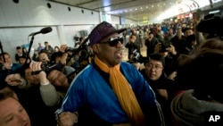 Former NBA basketball player Dennis Rodman is followed by journalists as he arrives at the Capital International Airport in Beijing from Pyongyang, Monday, Jan. 13, 2014.