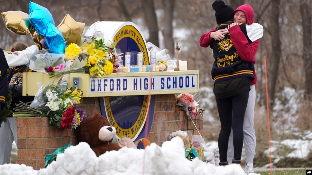 Students hug at a memorial at Oxford High School in Oxford, Mich., Wednesday, Dec. 1, 2021. (AP Photo/Paul Sancya)