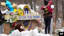 Students hug at a memorial at Oxford High School in Oxford, Mich., Wednesday, Dec. 1, 2021. (AP Photo/Paul Sancya)