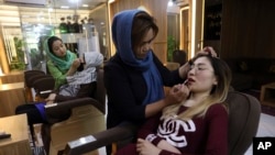Beauticians apply makeup on customers at Ms. Sadat’s Beauty Salon in Kabul, Afghanistan, Sunday, April 25, 2021. Kabul's young working women say they fear their dreams may be short-lived if the Taliban return to Kabul, even if peacefully as part of a new