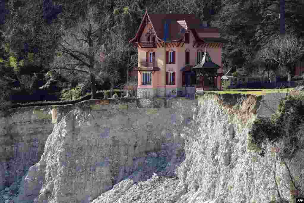 A house is seen on the edge of a landslide in the village of Saint-Martin-Vesubie, southeastern France, two months after heavy rains and floods left areas cut off from the world in the French Alps.