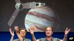 Scott Bolton, left, and Rick Nybakken are seen in a post-orbit insertion briefing at NASA's Jet Propulsion Laboratory following the solar-powered Juno spacecraft entered orbit around Jupiter on July 4, 2016, in Pasadena, Calif. (AP Photo/Ringo H.W. Chiu)
