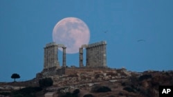 Hình minh họa - Mặt trăng mọc phía sau Ngôi đền của thần Poseidon bằng đá cẩm thạch cổ ở Athens, ngày 20 tháng 6 năm 2016. 